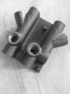 SMI duplex valve body multi-port cast iron — precision machined bores and port faces to customer drawing specification
