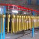 SMI PTO shafts on production spray line receiving yellow paint finish — batch surface treatment for OEM export supply