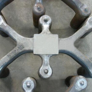 SMI cast steel anode yoke six-claw unit top view showing cylindrical claw end nodes and central square connection plate — in electrolytic aluminium cell service