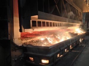Hot aluminium dross being skimmed from furnace into SMI dross pan — casthouse operation