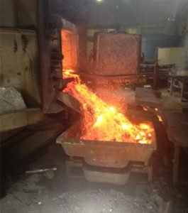 Liquid aluminium visible in freshly skimmed hot dross — immediate pressing required to prevent oxidation loss